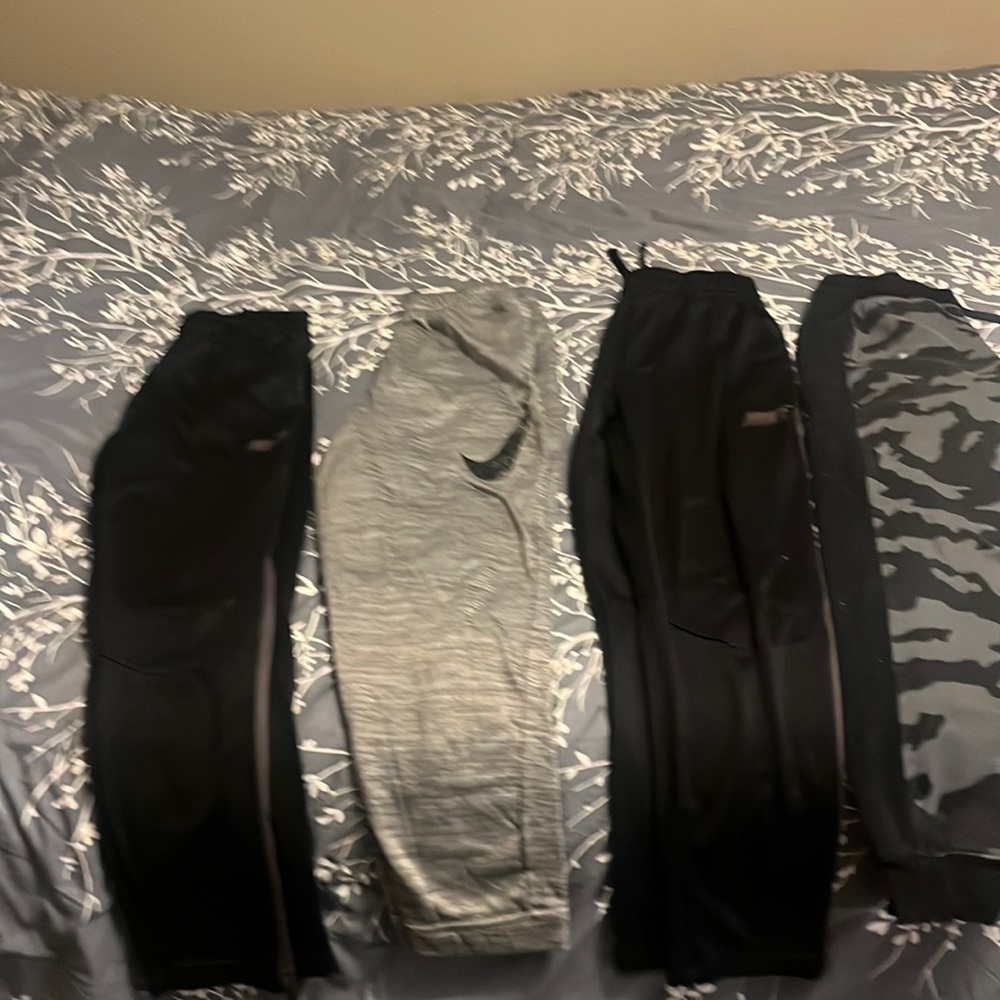 Three Nike and one under armor boys, extra large sweatpants
